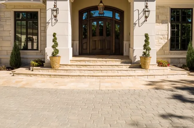 Concrete paver driveway leading to the front entrance, featuring light-colored interlocking pavers with a textured finish and subtle color variation.