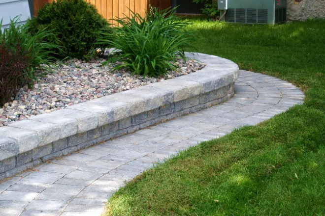 Concrete paver driveway leading to the front entrance, featuring light-colored interlocking pavers with a textured finish and subtle color variation.